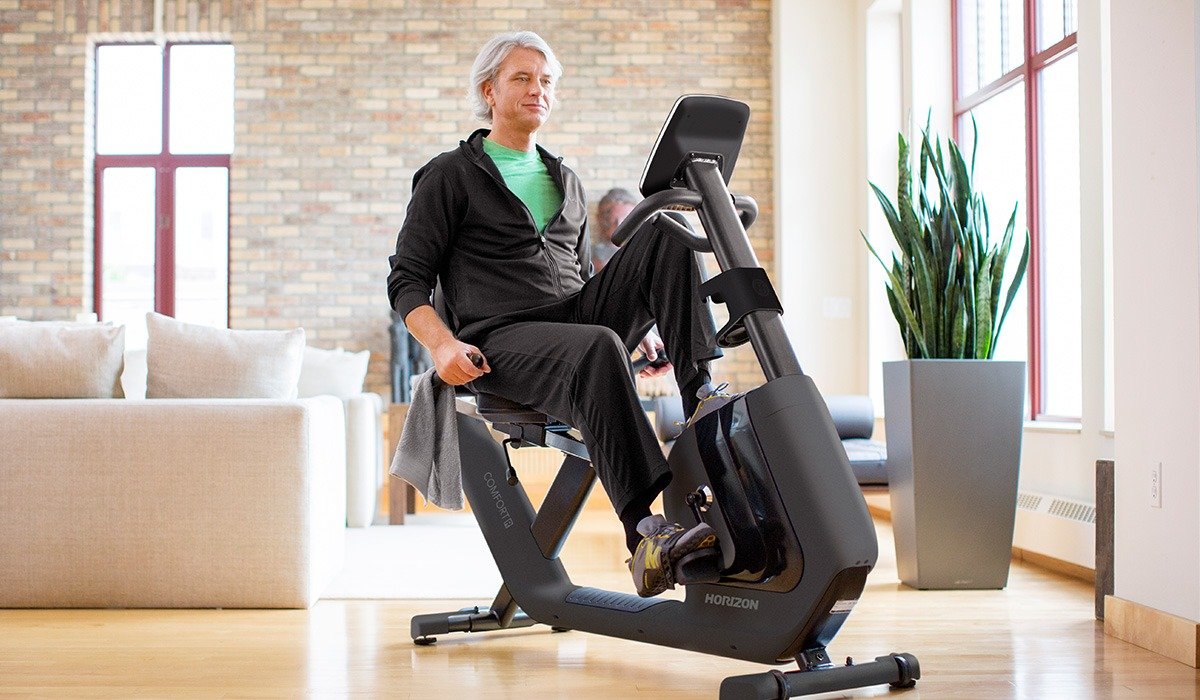 man in home gym riding a horizon recumbent exercise bike