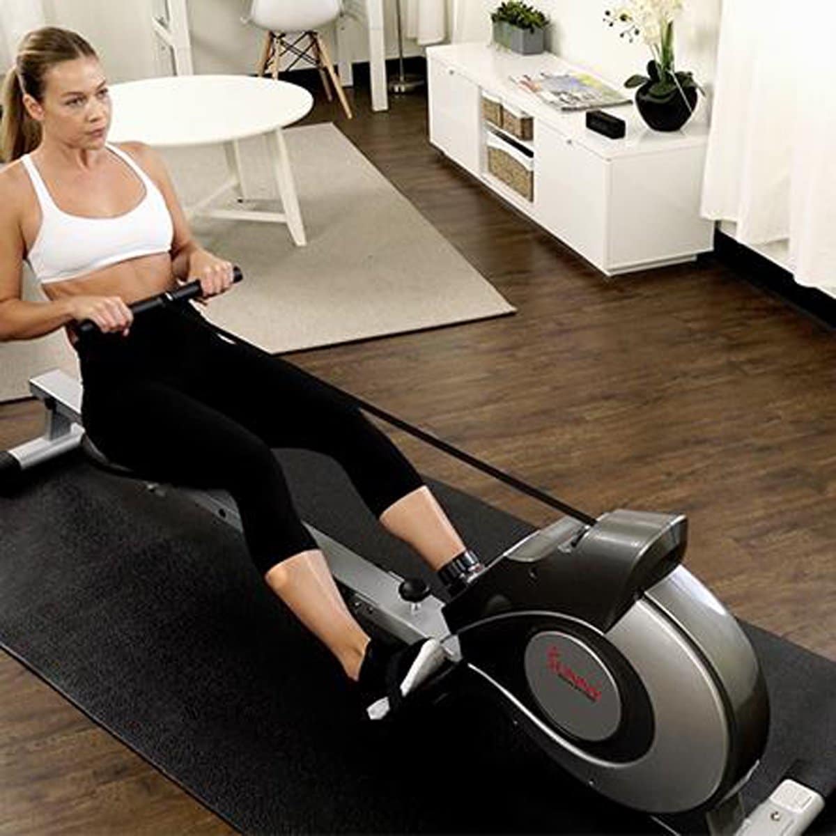 woman using a sunny health & fitness magnetic rowing machine