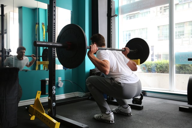 man performing a barbell back squat