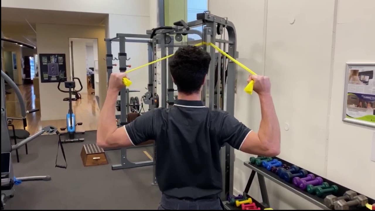 Man Doing Resistance Band Face Pulls In The Gym