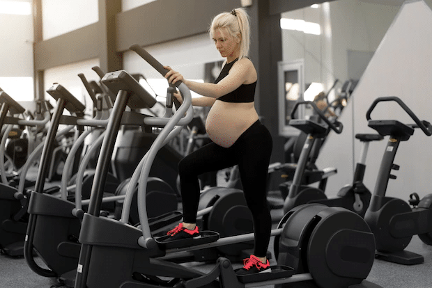 pregnant woman using elliptical machine