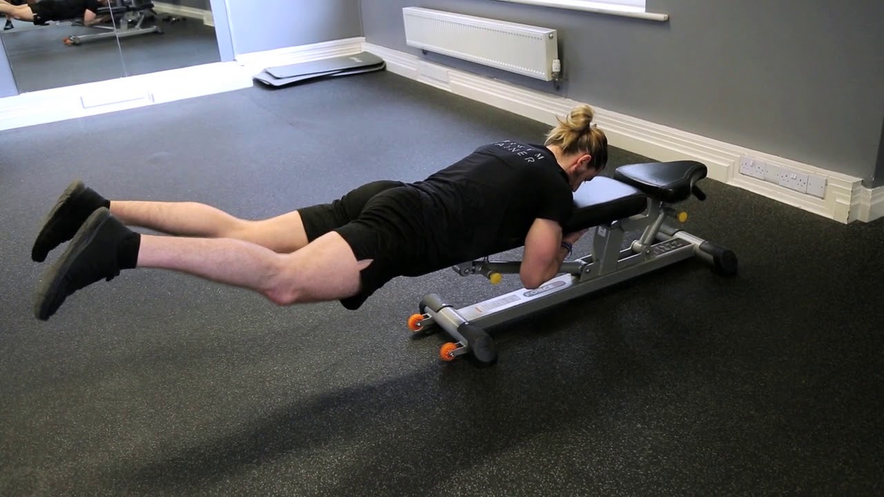 Man Doing Bench Reverse Hyperextensions In Home Gym