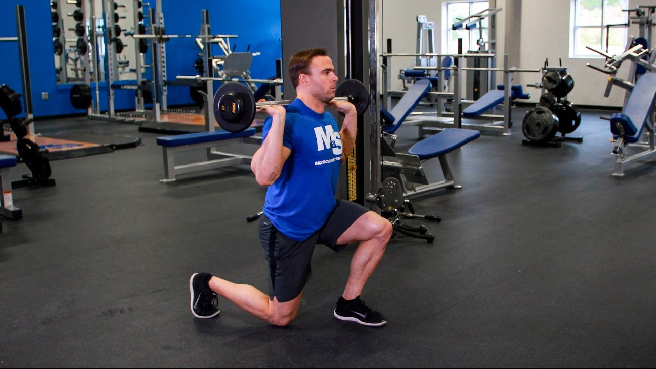 Man Doing Barbell Reverse Lunges In The Gym
