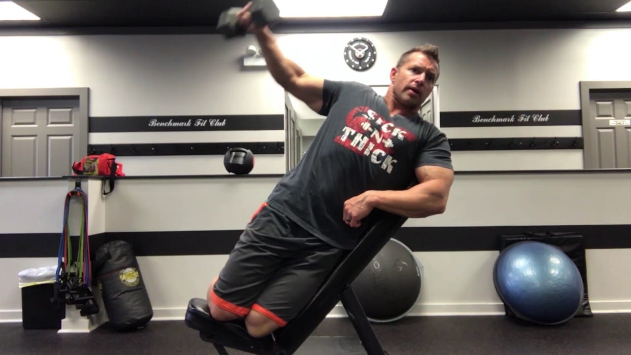 man in black and red t-shirt doing an incline lateral raise