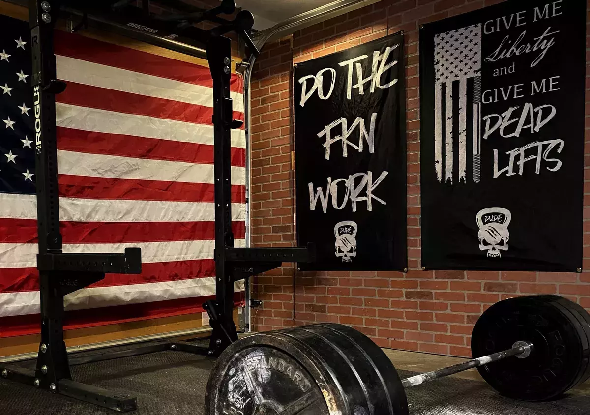 home gym with power rack and motivational gym flags and banners