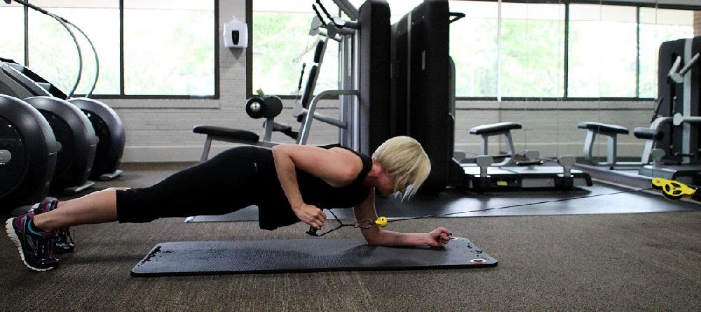 Woman Doing Plank Cable Row In The Gym