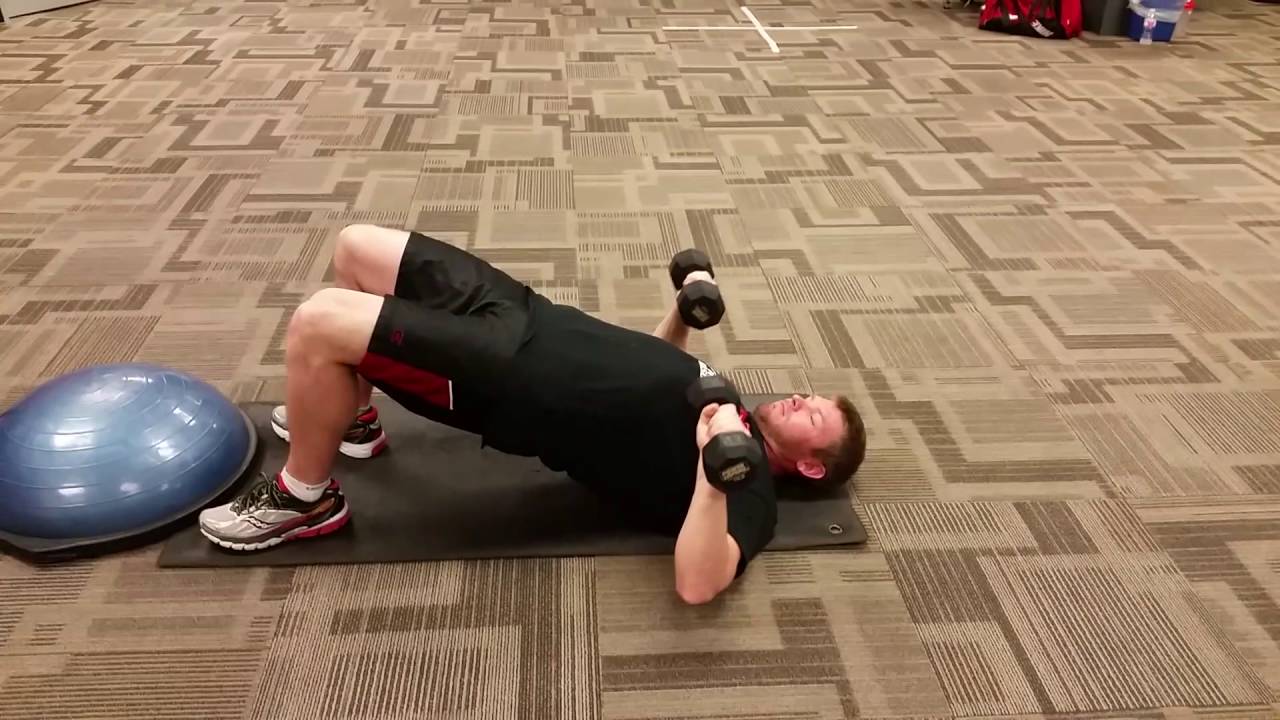 Man Doing Dumbbell Decline Floor Press in the Gym