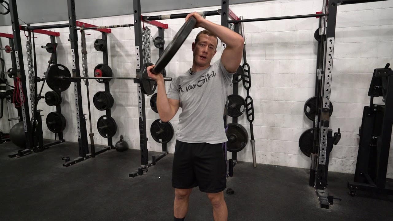 Man Doing a Weighted Plate Squat and Raise Exercise