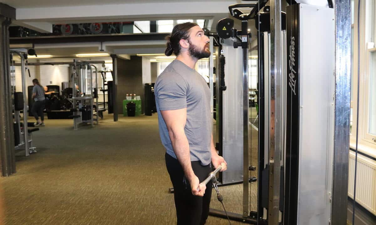 Man Doing Cable Curls In The Gym