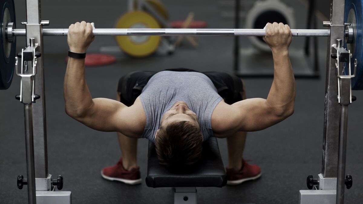 man doing barbell bench press exercise