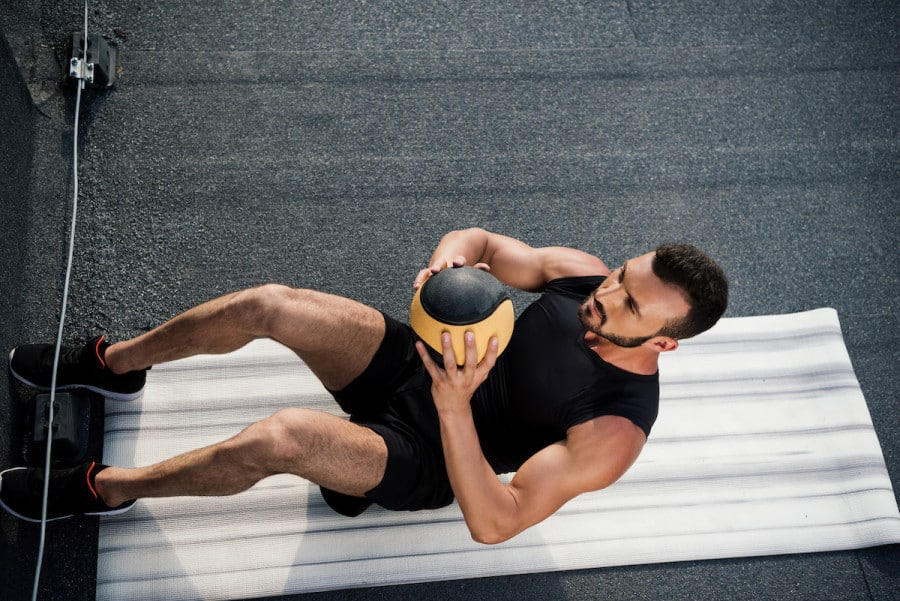 man doing medicine ball sit up and throw exercise