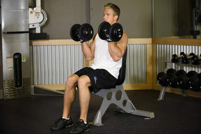man performing seated dumbbell curls
