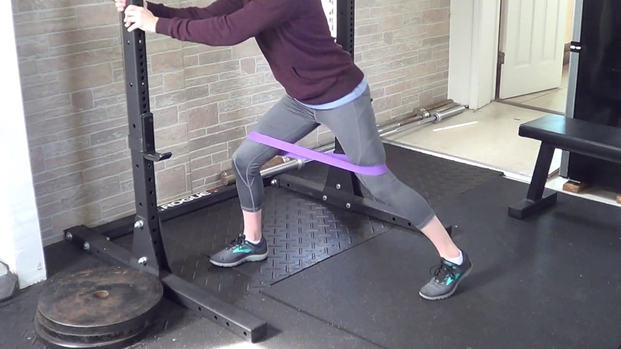 Woman Doing Leg Banded “Cha-Cha” Exercise In The Gym Woman Doing Leg Banded “Cha-Cha” Exercise In The Gym