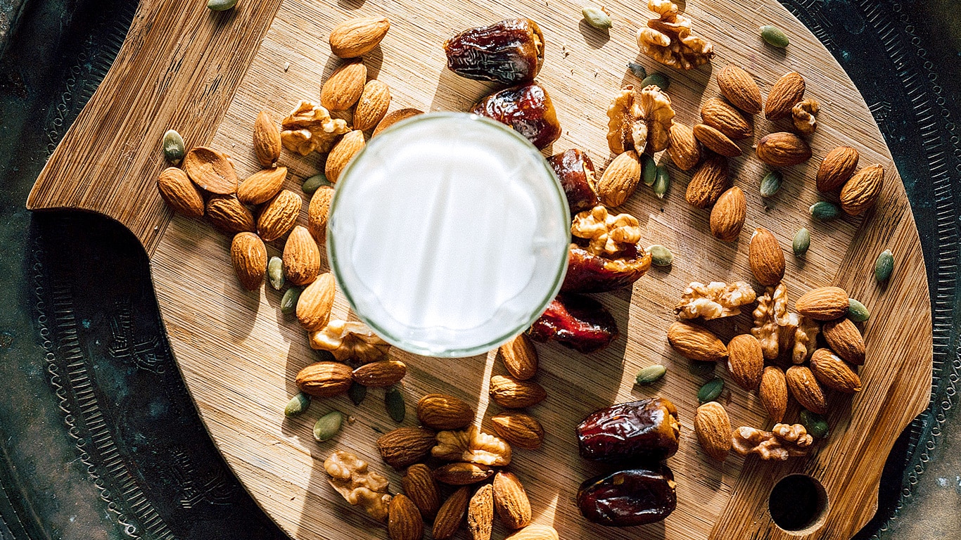 Almond Milk With Almond Nuts On A Wooden Chopping Board